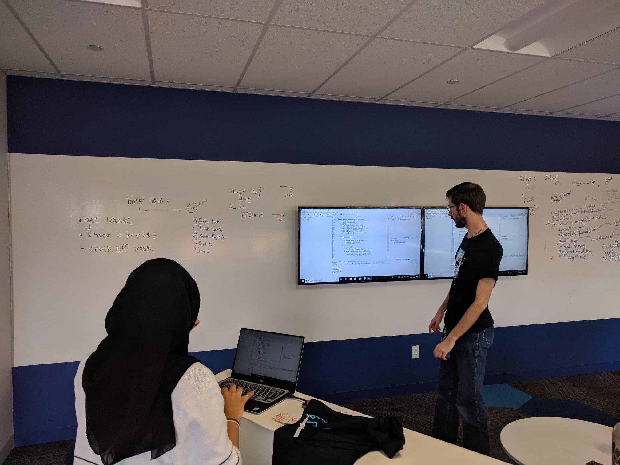 Andrew Judd mentoring a student at a whiteboard